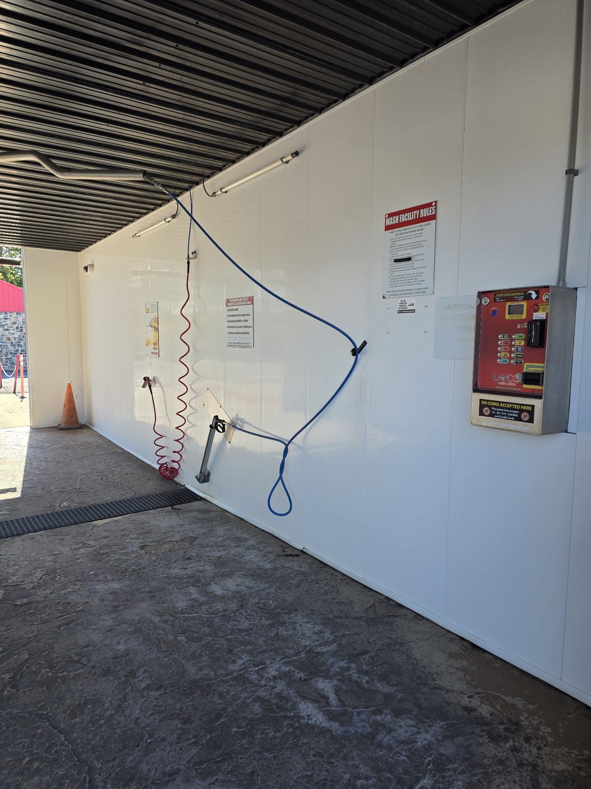 A Lanco self-serve bay with the LANCO meter box, wands and hoses on the wall